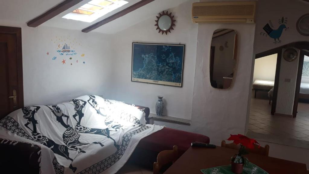 un salon avec un canapé et un miroir dans l'établissement Santa Teresa mansarda parking centro, à Santa Teresa Gallura