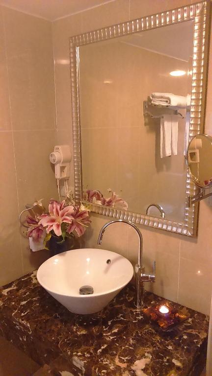 a bathroom with a sink and a mirror at Elegance Hotel in Taipei