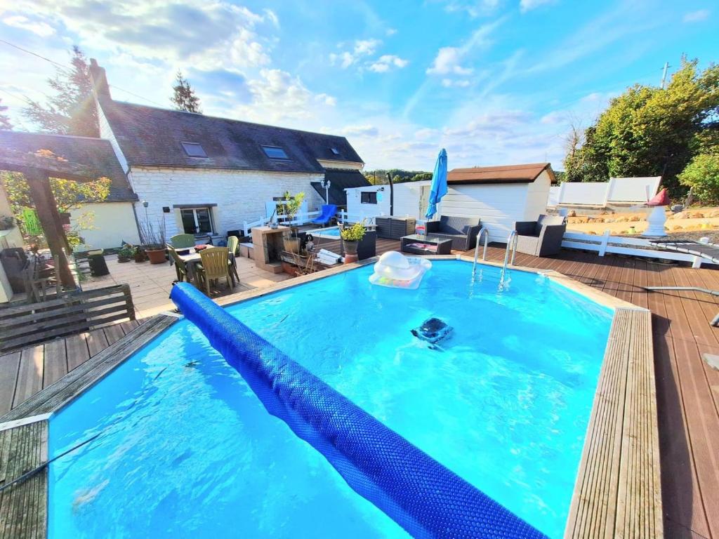 une piscine avec un toboggan bleu en face d'une maison dans l'établissement maison dans la Prairie, à Lhomme