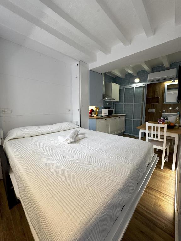 een groot wit bed in een kamer met een keuken bij Mazuelo - Harbor's Light in Villajoyosa