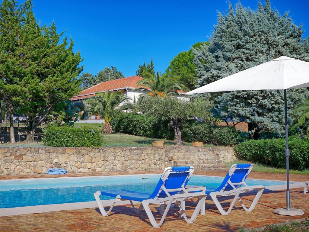 2 sillas y sombrilla junto a la piscina en Villa Tullio, en Capo dʼOrlando