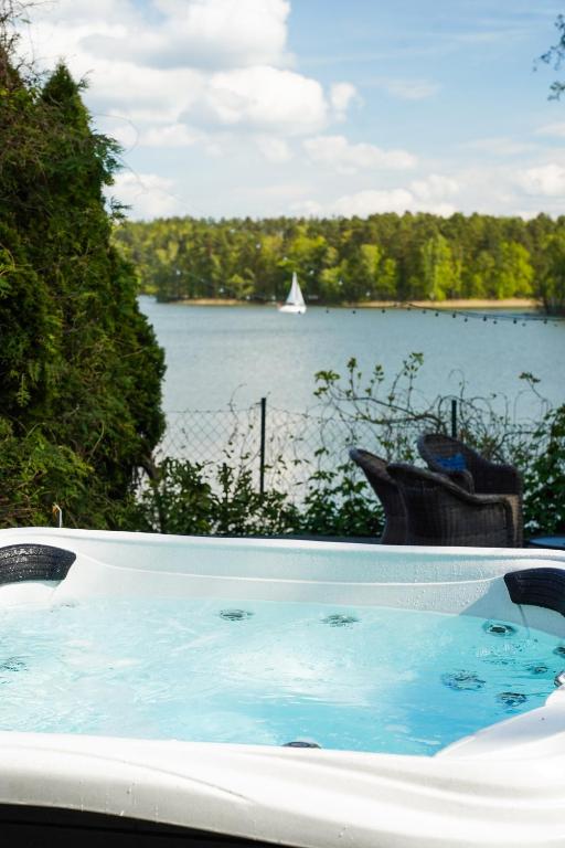 a bath tub with a view of a body of water at Dom Wiejska 39 a in Ruciane-Nida