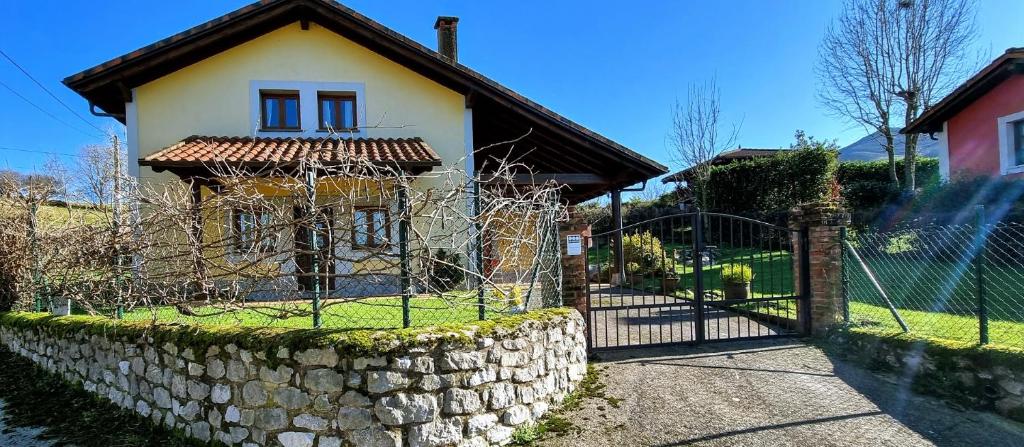 a fence in front of a house with a gate at Casa Vacacional El Alberu in La Borbolla