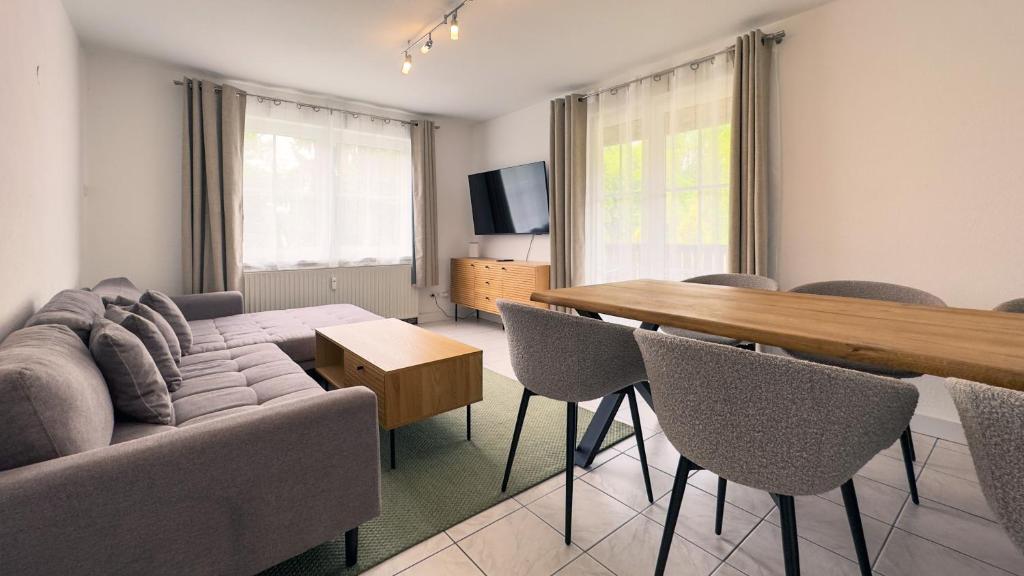 a living room with a couch and a table and chairs at Gemütliches Apartment in Velden in Velden am Wörthersee