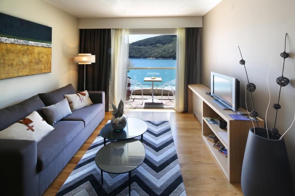 a living room with a couch and a tv at Boutique Hotel Adoral in Rabac