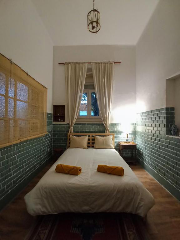 a bedroom with a large bed with two pillows on it at Montijo Garden - Alojamento Rural in Montijo