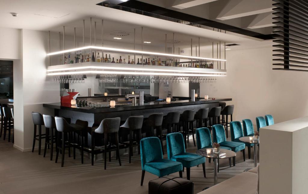 a bar in a restaurant with blue chairs at Wyndham Stuttgart Airport Messe in Stuttgart