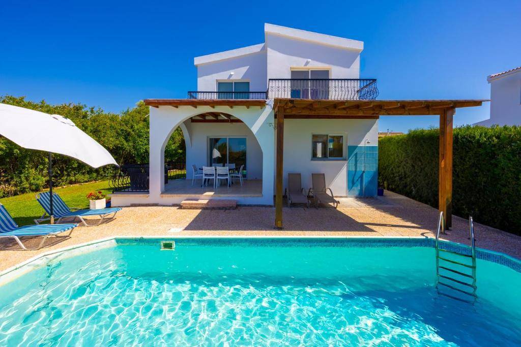 a villa with a swimming pool and a house at Villa Aristotelis in Argaka