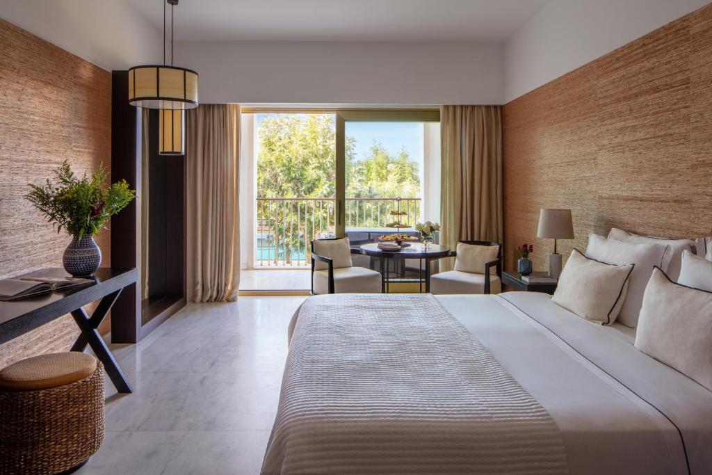 a bedroom with a large bed and a living room at Victoria Golf Resort and Spa Managed by Accor in Vilamoura