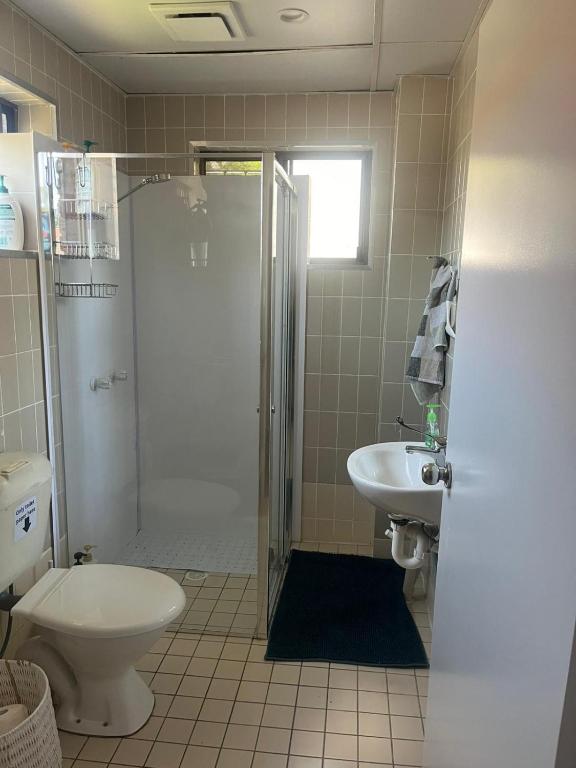 a bathroom with a shower and a toilet and a sink at The Gabba B&B in Brisbane