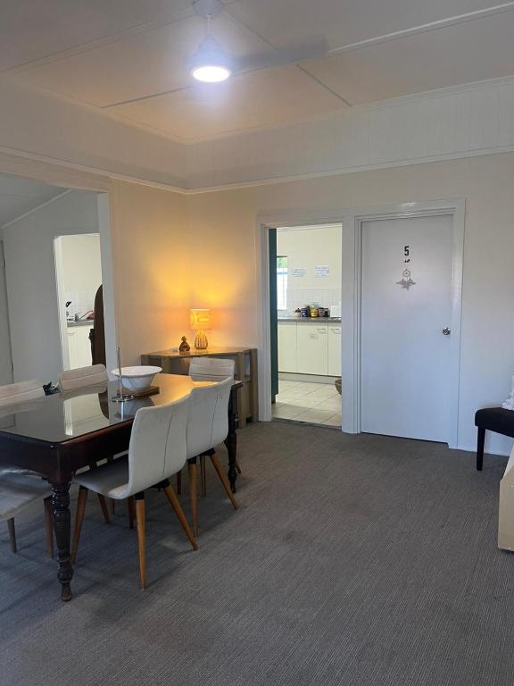 a living room with a table and chairs and a kitchen at The Gabba B&B in Brisbane