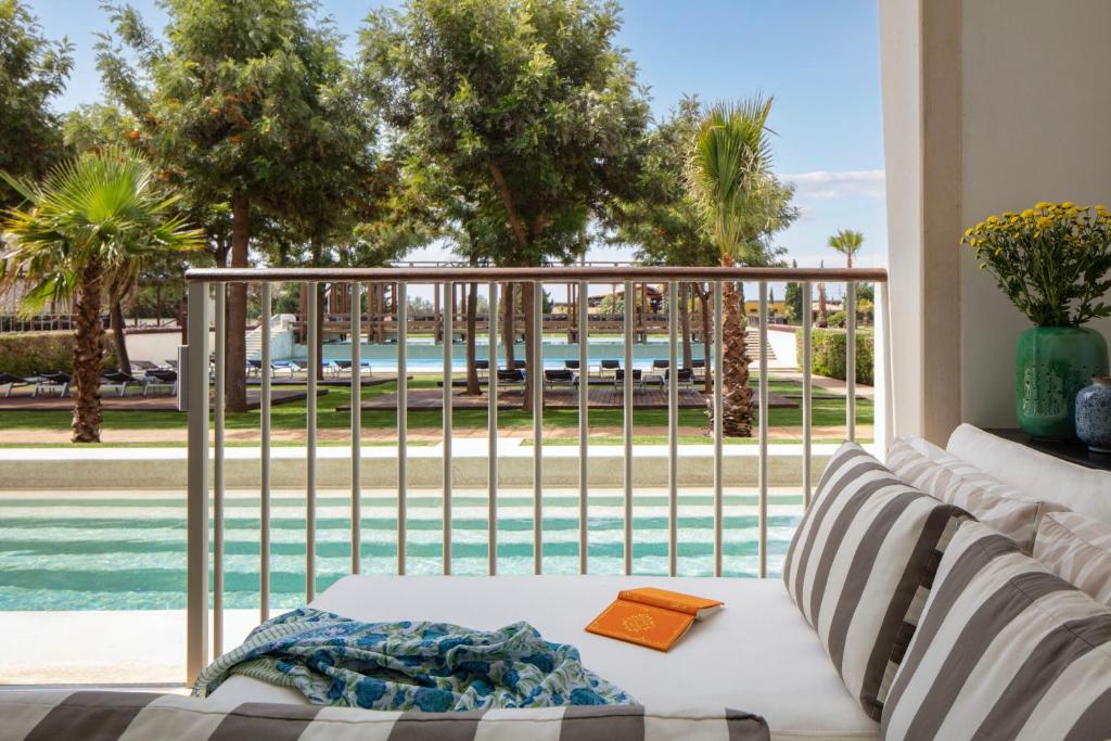 a living room with a couch and a view of a pool at Victoria Golf Resort and Spa Managed by Accor in Vilamoura