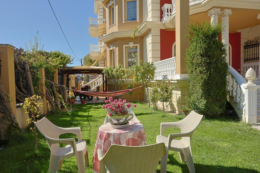a group of chairs and a table with a vase of flowers at Zeusplace Villa Evelin in Andromáchi