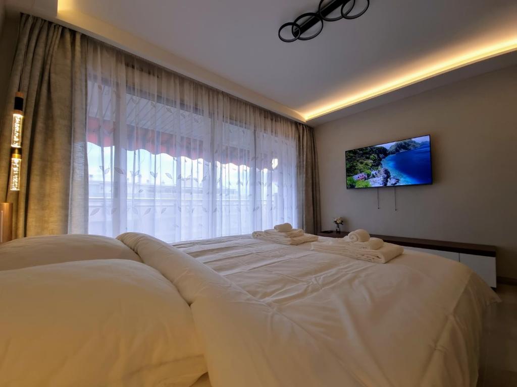 - une chambre avec un grand lit blanc devant une fenêtre dans l'établissement Studio Juan les Pins See View, à Antibes