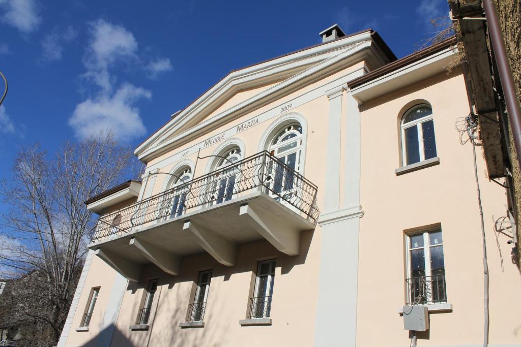 a building with a balcony on top of it at Marzia Rooms in Bormio