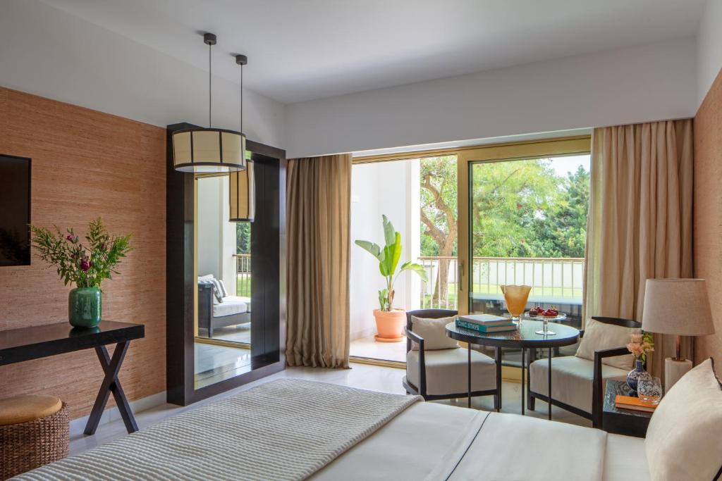 a bedroom with a bed and a living room at Victoria Golf Resort and Spa Managed by Accor in Vilamoura
