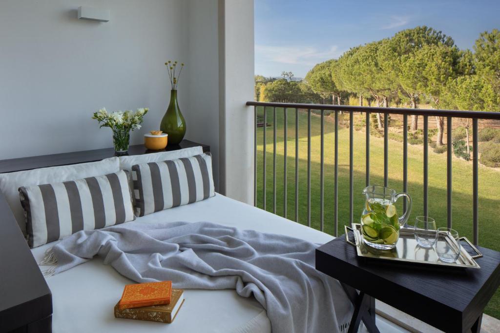 a bedroom with a bed and a balcony with a view at Victoria Golf Resort and Spa Managed by Accor in Vilamoura