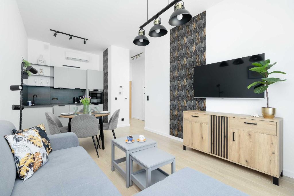 a living room with a couch and a table at Modern Apartment Nadmorska in Mrzeżyno with Parking near the Sea by Noclegi Renters in Mrzeżyno