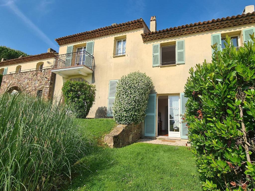 a large house with blue shutters and a yard at Holiday flats at Domaine de Saint-Endréol with golf, SPA and pool in La Motte
