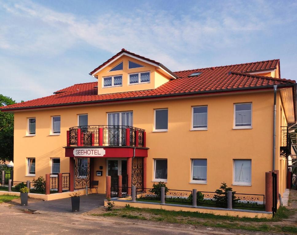 a yellow house with a red roof at Seehotel Bad Kleinen in Bad Kleinen
