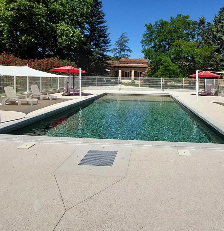 - une piscine avec 2 parasols et 2 chaises dans l'établissement Gîte de la Ferme des Rosières, à La Garde-Adhémar