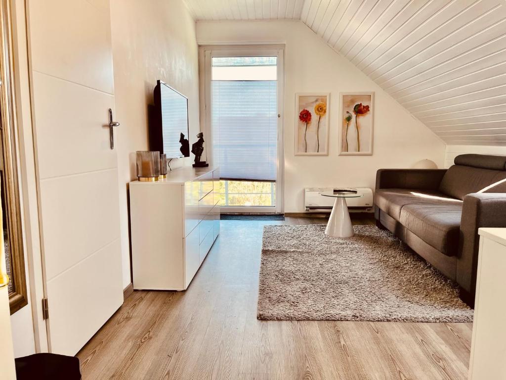 a living room with a couch and a cross on the wall at Casa Romano in Lüneburg