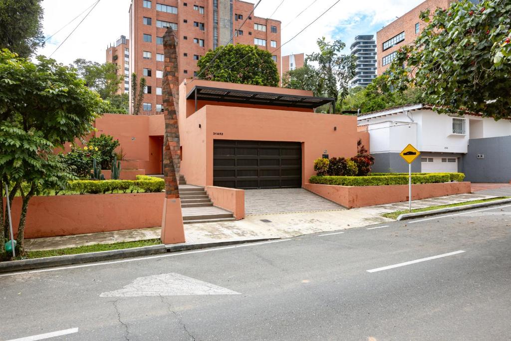 a house with a garage on the side of a street at 5BR Poblado Villa close to Lleras Jacuzzi Cinema AC in Medellín