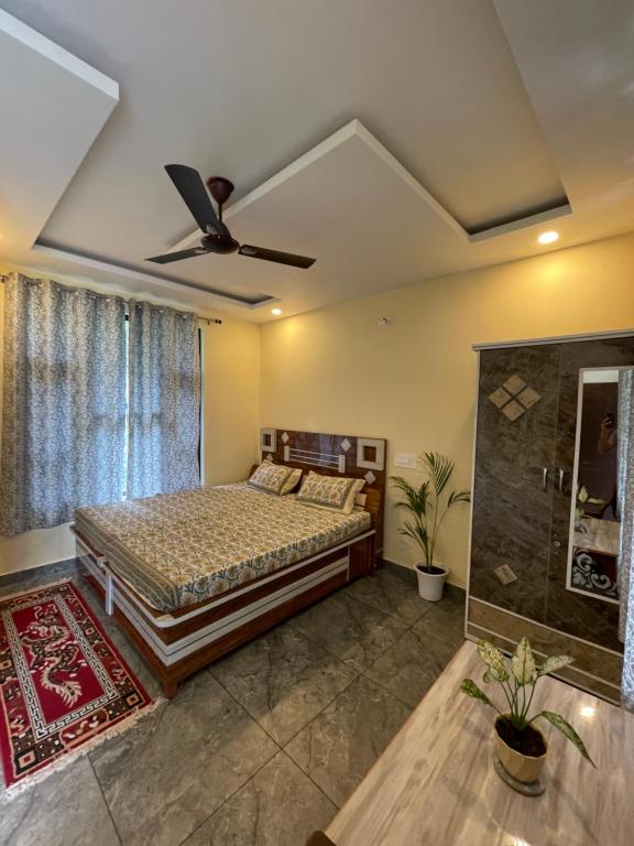 a bedroom with a bed and a ceiling fan at Secret garden homestay in McLeod Ganj