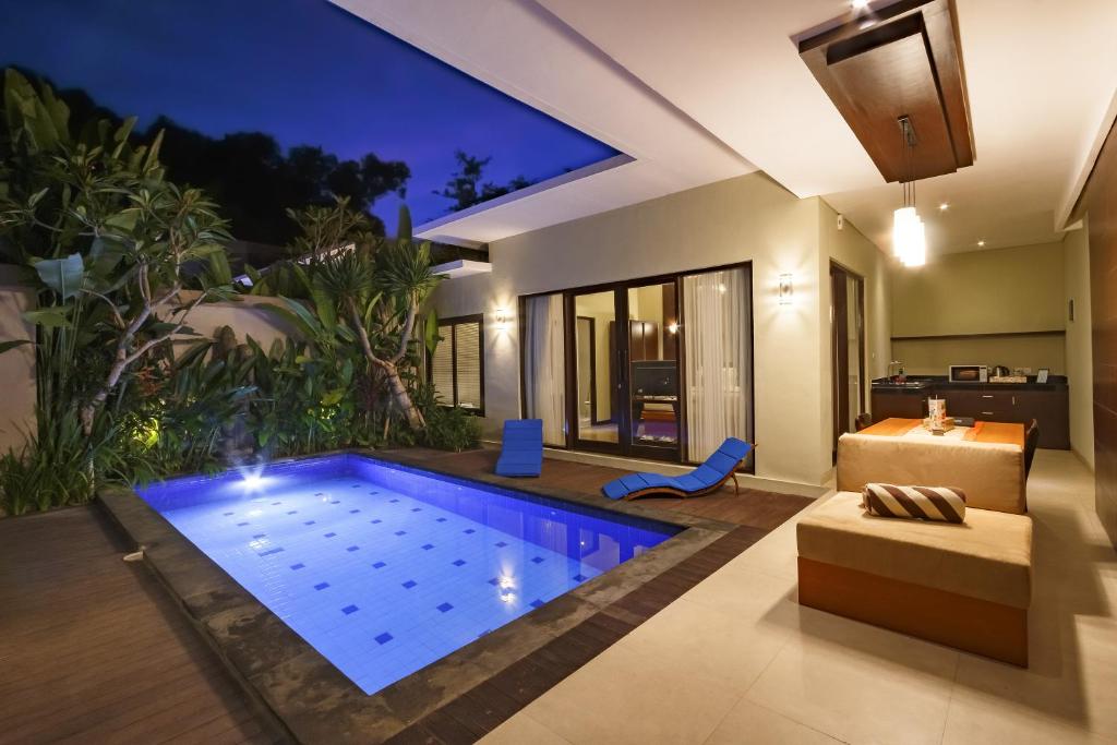 una piscina en medio de una sala de estar con sofá y sofá en Buana Bali Villas & Spa, en Jimbaran