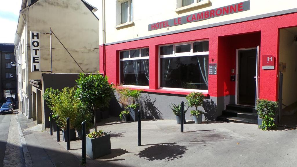 un bâtiment rouge avec des plantes en pot devant lui dans l'établissement Hôtel Le Cambronne, à Nantes