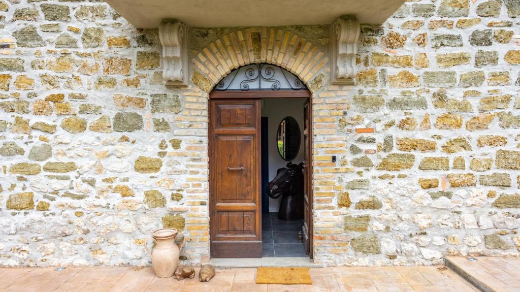 a stone building with a wooden door and a stone wall at Casale Paolina by Rentbeat in Ceccano
