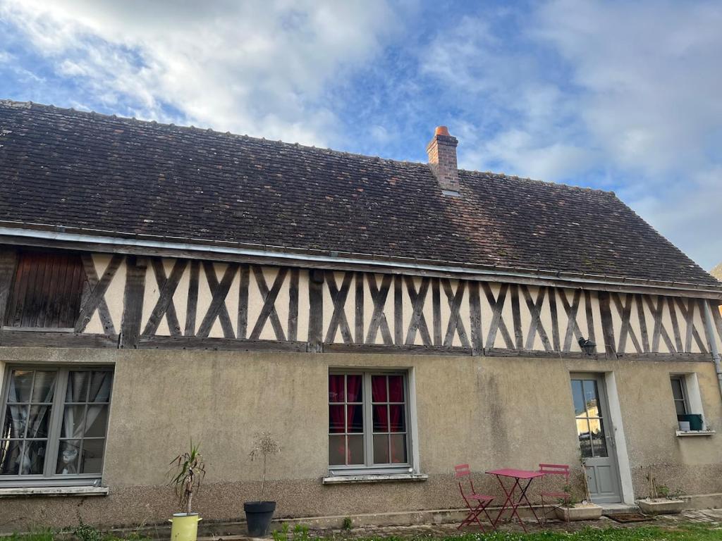 an old house with a roof and two windows at La petite maison in Souday