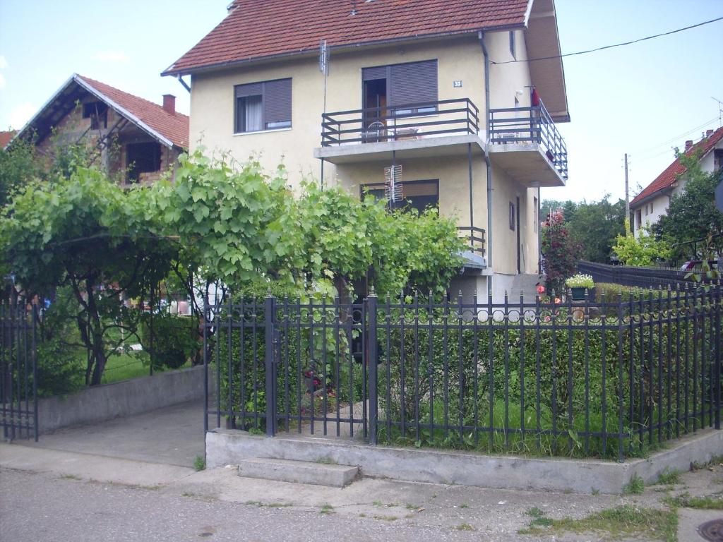 une maison avec une clôture en fer noir devant elle dans l'établissement Guest House Nada, à Sokobanja