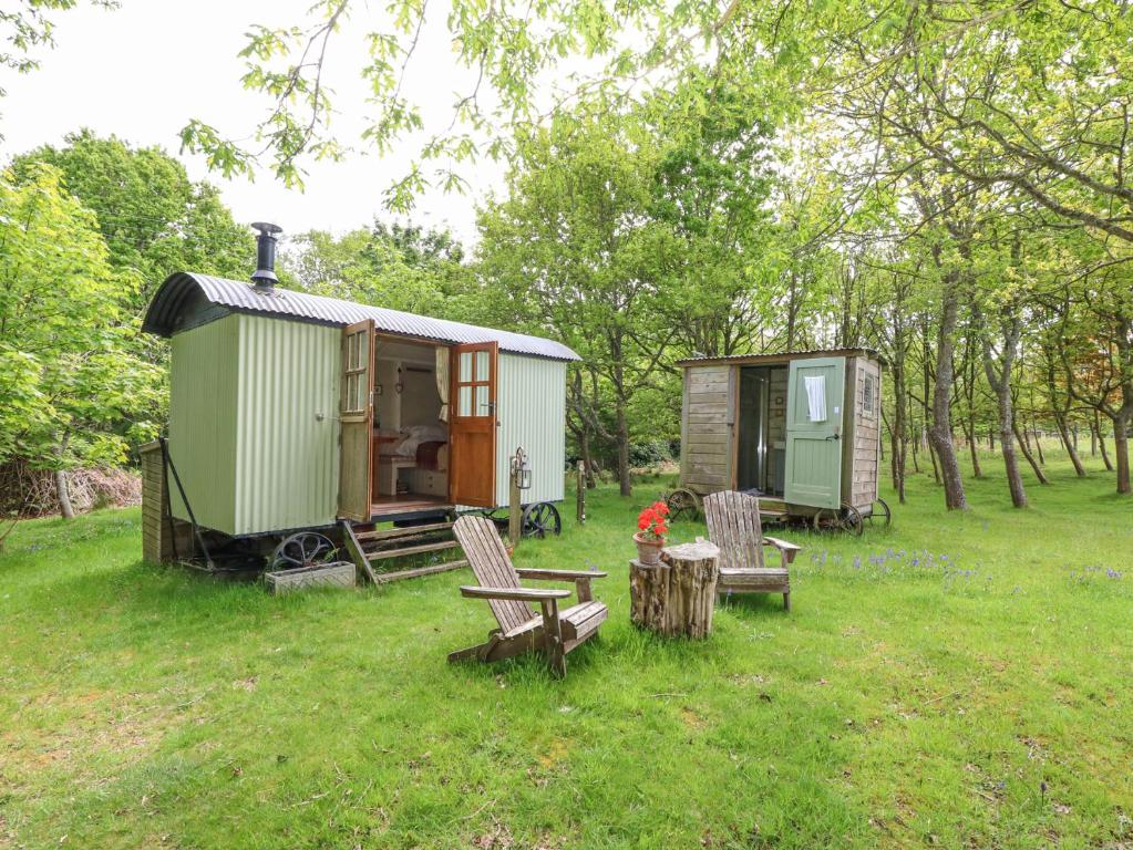 a green cabin with a table and chairs in the grass at Sika in Dorchester