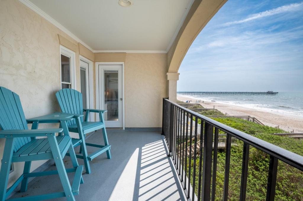 a balcony with two blue chairs and the beach at Villa Capriani 218B Oceanfront with Pool at North Topsail Beach in Chadwick Acres