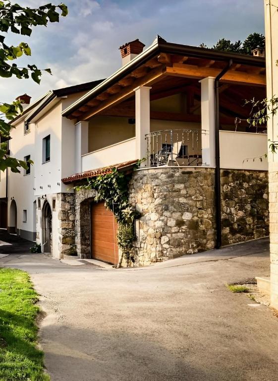 a house with a stone wall and a garage at Apartmaji Tanto Malovše in Črniče