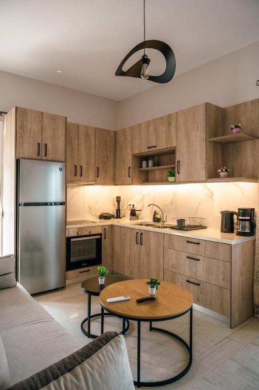 a kitchen with wooden cabinets and a stainless steel refrigerator at Euphoria Loft in Karfas