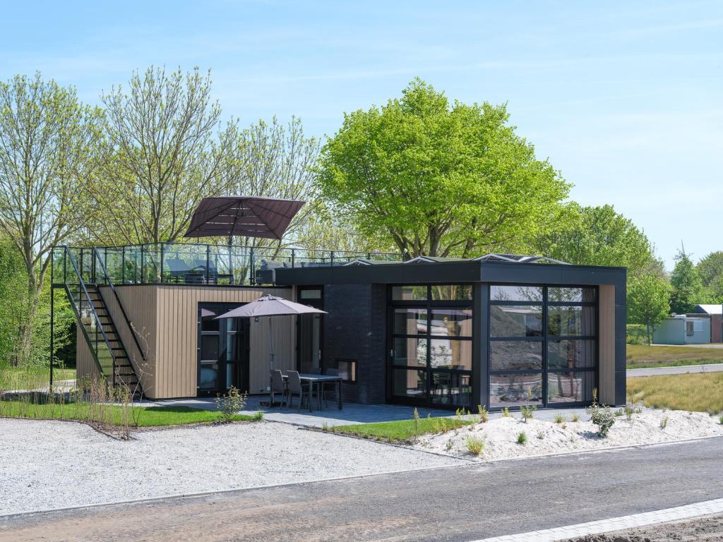 a small black house with a glass roof at MarinaPark Beach Resort Soal | Beachfront villas in Workum