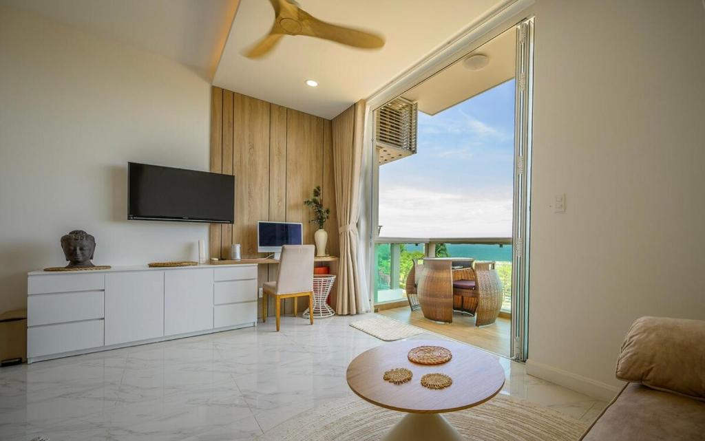 a living room with a couch and a tv and a table at Beach Studio in Ấp Phú Tịnh (2)