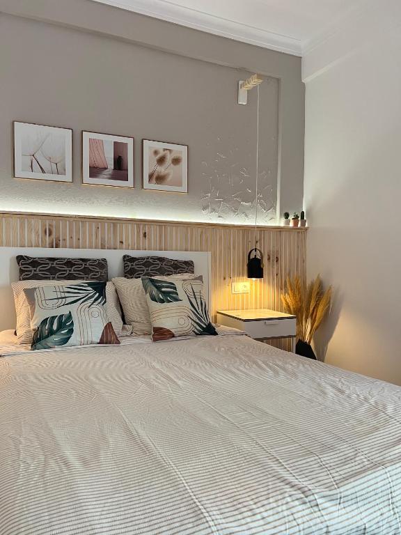 a bedroom with a large white bed with pillows at Quarto confortável com varanda in Amadora