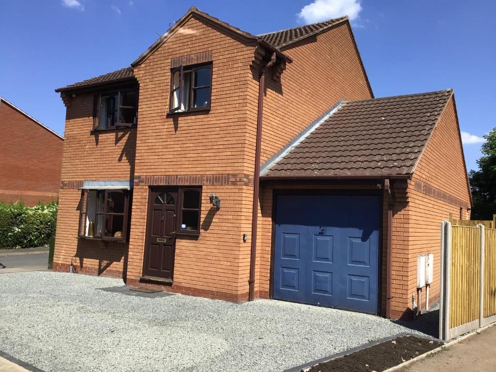 ceglany dom z garażem z niebieskimi drzwiami w obiekcie Stunning Fir Trees Corner 3 bedroom detached Executive house with free drive way parking for 2 vehicles 1 mile from M5 dogs welcome w mieście Worcester
