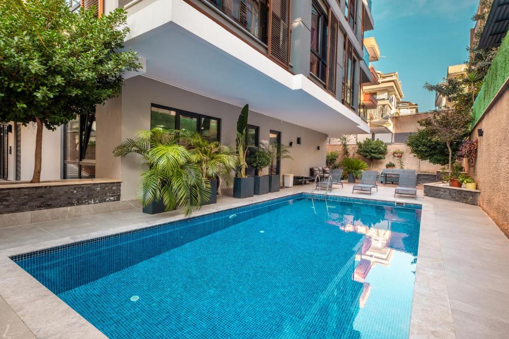 a swimming pool in front of a building with a house at Retro 2 in Alanya