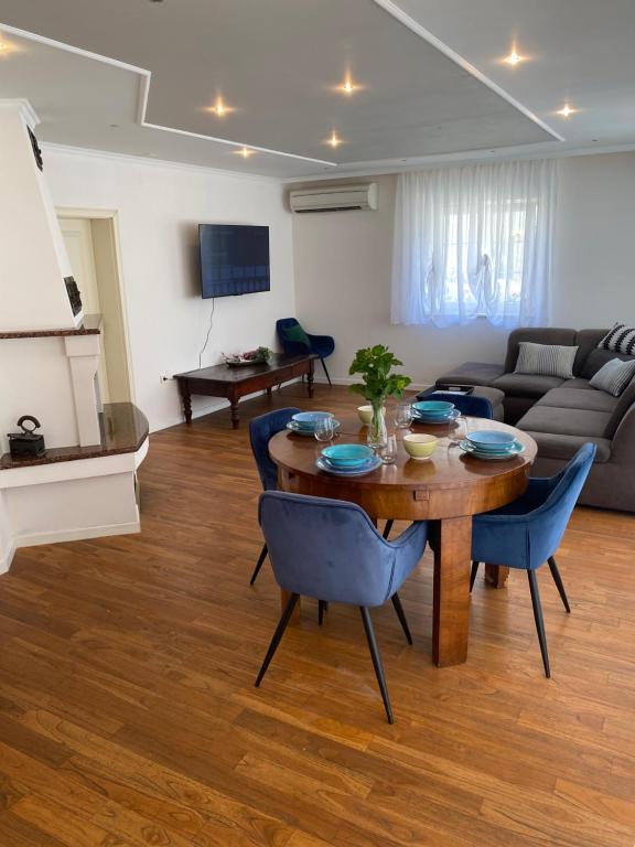 a living room with a wooden table and blue chairs at Private pool,3 bedrooms and 3 bathrooms in Biograd na Moru