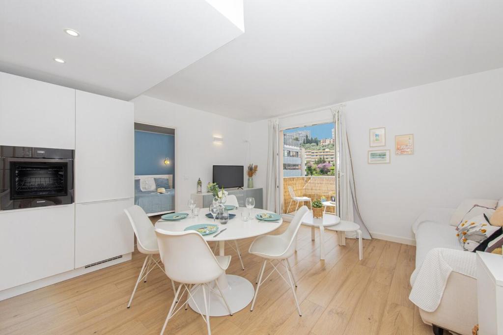 un salon blanc avec une table et des chaises blanches dans l'établissement Jardin du cap, à Roquebrune-Cap-Martin