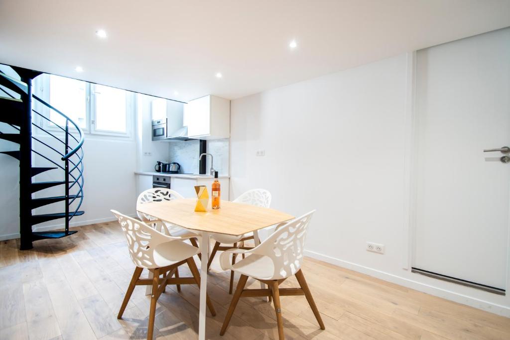 une cuisine et une salle à manger avec une table et des chaises en bois dans l'établissement CIA - Flat in Bonne Nouvelle, 4P, à Paris