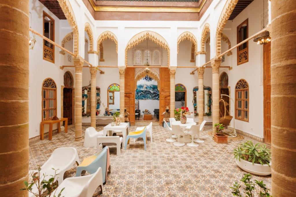 a courtyard with tables and chairs in a building at Riad DAR tya in Sale