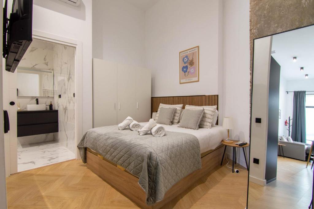 a bedroom with a large bed and a bathroom at Luxe Appartement in Valencia - Dichtbij strand in Valencia