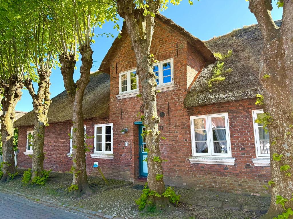 ein altes Backsteinhaus mit Strohdach in der Unterkunft Altenteil in Oldsum