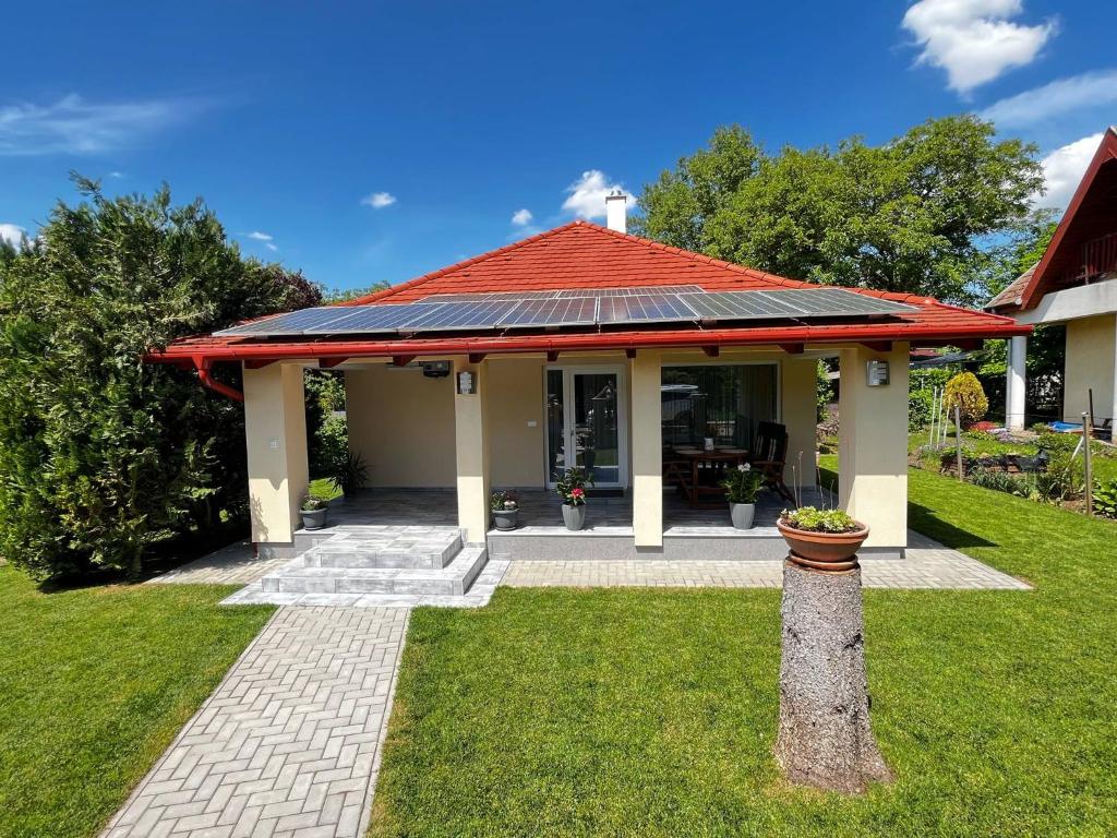 a house with a red roof with a porch at Vadvirág Vendégház Gárdony in Gárdony