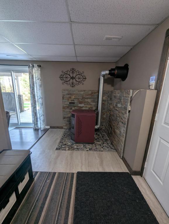 a living room with a refrigerator and a brick wall at Suite in the Bush-Private Apartment in Bancroft